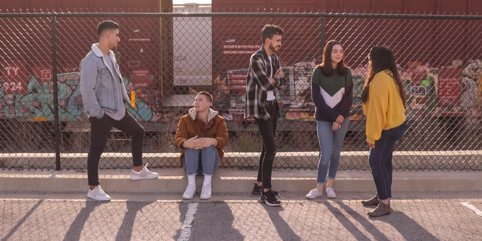 five persons on front of chain link fence