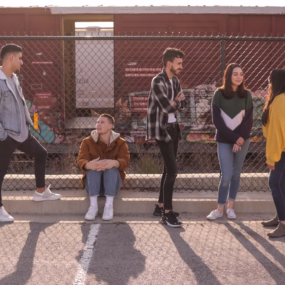 five persons on front of chain link fence