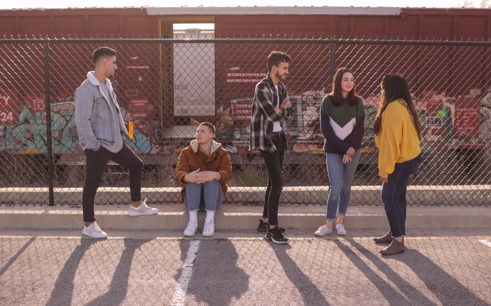 five persons on front of chain link fence